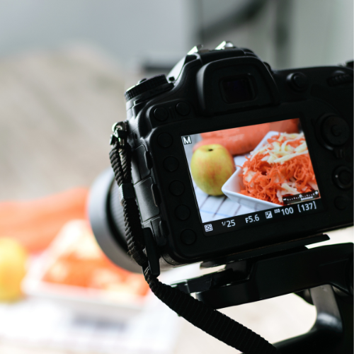 An example of Shopify product photography where a camera is capturing a dish on a screen with food in the background